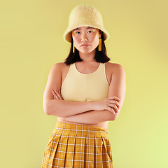 Image showing Asian, woman in portrait and fashion with yellow aesthetic, beauty and confident with arms crossed on studio background. Style, edgy and female with streetwear, trendy designer clothes and mockup