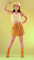 Image showing Smile, power and asian woman flexing arm, full body portrait of gen z model with trendy fashion win in studio. Feminism, empowerment and strength, happy and strong girl isolated on yellow background.