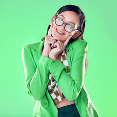 Image showing Woman, smile and fingers on face by green background, studio and happy smile for career vision. Young model, retro aesthetic and ideas with glasses, vintage fashion, pride and happiness by backdrop