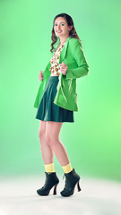 Image showing Fashion, beauty and portrait of a woman in a studio with a trendy, stylish and edgy outfit. Happy, smile and young female model with style and cool clothes posing while isolated by a green background