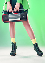 Image showing Radio, woman and music with retro technology and fashion, entertainment with station, funk and legs on green background. Style, vintage sound and audio equipment, female boots with broadcast device