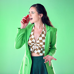 Image showing Fashion, phone call and annoyed woman in a studio on a mobile argument, conflict or disagreement. Style, trendy and female model talking on a cellphone with a edgy outfit isolated by green background