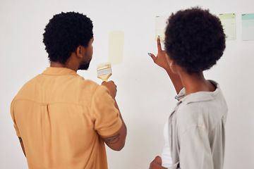 Image showing Painting, wall or black couple in DIY, home renovation or house remodel together with a paintbrush. Back view, partnership or African man speaking to a woman working with team work or collaboration