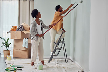 Image showing Painting, teamwork or black couple home renovation, diy or house remodel together with paintbrush or roller. Happy smile, woman and African man love working on wall with partnership or collaboration