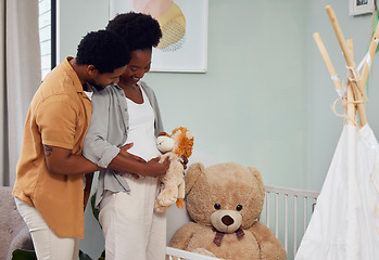 Image showing Love, teddy bear and pregnant couple in the nursery with excitement while preparing for their baby. Happy, pregnancy and young African man with his maternal wife looking at toy together in bedroom.