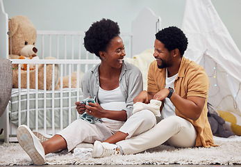 Image showing Funny, laundry and black couple getting ready for a baby, folding clothes and preparation in pregnancy. Happy, parents and pregnant woman and man sitting with clothing for child and conversation