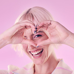 Image showing Portrait, woman and hands with heart, smile and freedom with confident girl against studio background. Face, female hipster and lady with gesture for love, emoji and support with style and trendy