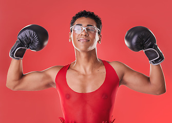 Image showing Portrait, boxing and strong gay man with motivation isolated on a red background in a studio. Fight, fitness and lgbt person showing muscle from self defense exercise, training and challenge