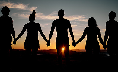 Image showing Friends, bonding or holding hands on sunset beach silhouette, nature freedom or community trust support. Men, women or people sunrise shadow in solidarity, team building help or travel mission goals