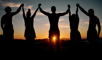 Image showing Friends, celebration and holding hands on sunset beach silhouette, nature freedom or community trust support. Men, women and people sunrise shadow in solidarity, team building or travel bonding goals