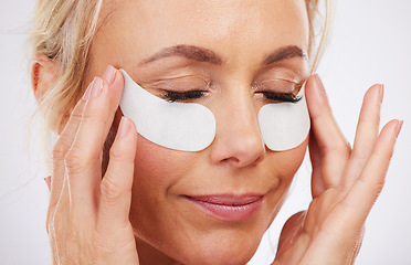 Image showing Skincare, eye mask and collagen, mature woman, anti ageing wrinkle treatment and isolated on grey background in studio. Health, skin and beauty model face with patches on eyes for luxury spa facial.