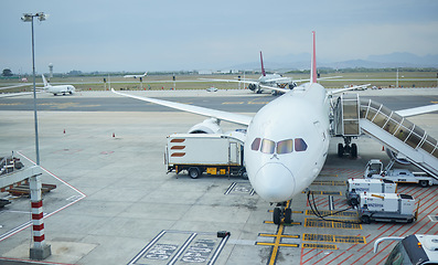 Image showing Airplane, airport or loading luggage for traveling outdoors on runway at worldwide location for journey. Trip, transportation services or commercial aeroplane on ground for international flight cargo