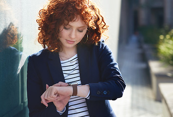 Image showing Woman in city, checking time and smartwatch on wrist on morning commute to work or appointment. Street, schedule and businesswoman looking at watch on urban sidewalk before job interview or meeting.