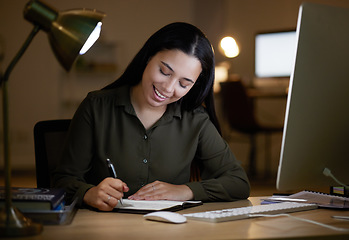 Image showing Happy, writing or business woman on notebook at night for creative idea, journal entry or proposal report. Smile, overtime or manager planning for company strategy or research notes on office desk