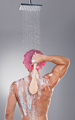 Image showing Back, shower and man cleaning, water splash and hygiene with wellness, skincare and on grey studio background. Muscular male, guy and washing with soap, foam and scrub for body care and backdrop