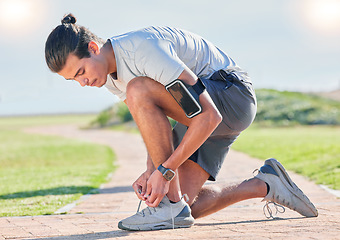 Image showing Shoes, fitness man and runner tying laces for running, exercise and training outdoor. Sports, pavement and park run of a athlete doing wellness and health sport for marathon or race in summer