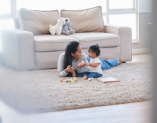 Image showing Baby, mom and living room fun of a mother and kid with toys for knowledge development. Smile, happiness and parent care on a lounge rug in a home with mama love and bonding together with a child