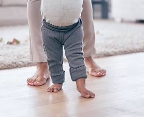 Image showing Baby feet, walking and learning with mother in a living room lounge with mobility development. Floor, home and first steps of a young kid with mama together with love, care and support in a house