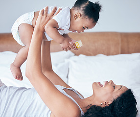 Image showing Happy mom, bedroom and baby in the air with parent care and love at home in morning, Child, mother and happiness of a young mama with a kid playing and having fun together in a house with childcare