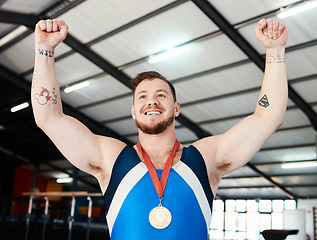 Image showing Man, medal celebration and winner with smile, indoor sports or hands in air at competition with pride. Champion athlete, happy and winning with gold, celebrate or success in global gymnastics contest