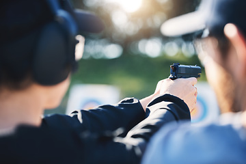 Image showing Man, woman and gun training with target, outdoor challenge and aim at police, army or security academy. Shooting coach, pistol or firearm for sport, safety and combat exercise in nature with vision