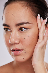 Image showing Beauty, hand on face and woman in studio for skincare, dermatology and cosmetics for skin glow. Aesthetic asian model person with makeup, mole and luxury facial self care for health and wellness