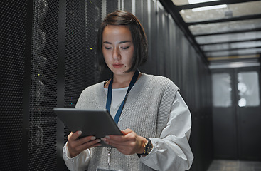 Image showing Tablet, server room and security with a programmer asian woman at work on a computer mainframe. Software, database and information technology with a female coder working alone on a cyber network