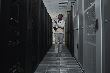 Image showing Technician, cybersecurity and man in the server room for data maintenance, it or analysis. System, engineer and African male coder or programmer doing inspection on information technology in office.