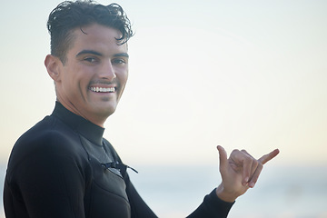 Image showing Shaka, portrait and man surfer at the beach for water sports training or exercise while on vacation. Happy, smile and male athlete with a hang loose hand sign ready for a surfing workout in Australia