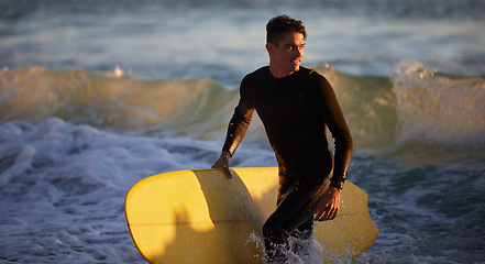 Image showing Sea, sports and surfing with a man in the water by the beach for fitness or training for a competition. Ocean, wetsuit and surfboard with a male athlete outdoor for an exercise or workout routine