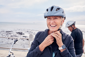 Image showing Happy senior woman, bicycle and helmet on holiday ride at beach for fitness workout with man. Smile on face, happiness and health, cycling exercise for mature couple on ocean vacation in Australia.