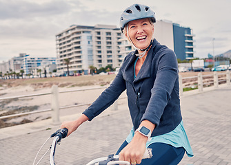 Image showing Fitness, promenade and woman riding a bicycle for exercise, health and wellness by the beach. Sports, smile and portrait of happy senior female cyclist cycling for outdoor cardio workout or training.