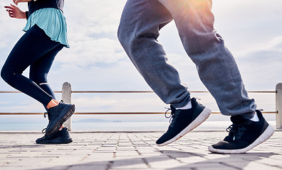 Image showing Legs of people, fitness and running at promenade beach for energy, wellness and workout. Closeup man, woman and feet outdoor for cardio exercise at sea for marathon training, shoes and sports runners