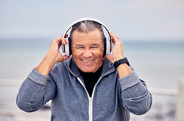Image showing Portrait, music and fitness with a senior man outdoor on the promenade for a cardio or endurance workout. Headphones, running and training with a mature male outside by the beach for exercise
