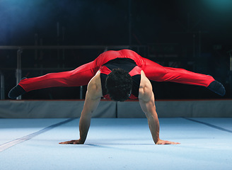 Image showing Gymnastics, handstand and man on gym floor for training, balance and wellness with muscle, strong body and night. Gymnast, athlete and exercise in studio for competition, goals and fitness for sport