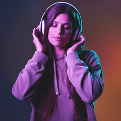 Image showing Music, neon and gen z with a woman in studio listening to the radio for freedom on a wall background. Cyberpunk, headphones and streaming audio with an attractive young female hearing her best song