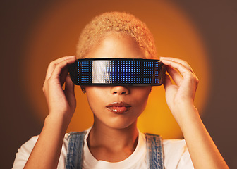 Image showing Black woman, vr and futuristic cyberpunk glasses in online metaverse app or game or video on brown background. Virtual reality, future fashion and digital augmented reality goggles on model in studio