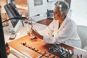 Image showing Senior optometrist woman, glasses and design for focus, vision or frame planning at desk in clinic. Elderly optician, spectacle designer and eye care in workplace for fashion, small business and goal