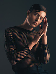 Image showing Gender neutral, face and fashion, portrait on dark background and trendy, edgy with hands. Creative, gen z and beauty, sexy and cosmetics with serious non binary person in designer clothes