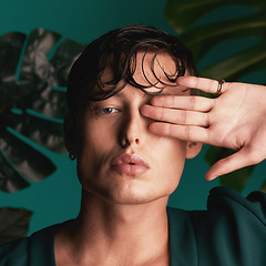 Image showing Gen z, man and portrait of a male model with hand beauty and fashion face. Isolated, green background and studio of a young person with Monstera plants for organic skincare and eco friendly style