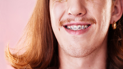 Image showing Face, teeth and dental with man in braces, orthodontics and beauty with cosmetics and healthcare on pink background. Young, gen z and fashion, oral care and mouth zoom, smile and health insurance