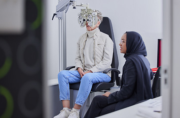 Image showing Vision, eye exam and senior woman with optometrist in clinic for testing, eyesight and optical assessment. Optometry, healthcare and Muslim optician with patient, phoropter and medical tool for eyes
