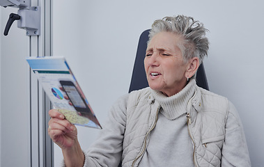 Image showing Senior woman, optometrist office and reading for snellen test, nearsighted problem or hospital consultation room. Elderly patient, healthcare or paper for eyes, focus and retirement at clinic check