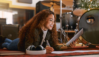 Image showing Black woman, smile and tablet writing music in recording studio for audio track, content creation or development. Happy African female song writer smiling in lyrics holding touchscreen lying on floor