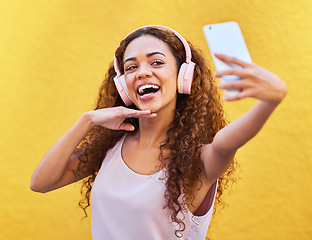 Image showing Music, happy black woman and headphones for selfie on yellow wall background. Face of gen z person with a smile outdoor for listening or streaming motivation audio for influencer post in Colombia