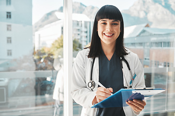 Image showing Woman, doctor and portrait smile writing on clipboard by window for healthcare planning, strategy or notes. Female medical expert smiling with paperwork, prescription or medicare details at hospital