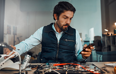 Image showing Computer hardware repair, phone and it worker watch a diy video to fix a semiconductor and circuit. Engineering, workshop and electric work of a male engineer with a mobile doing electrical project