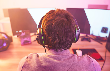 Image showing Back of man, streamer and video game on computer in home, desk or online games of virtual competition. Geek gamer, live streaming and gaming with headphones in neon lighting, esports tech or gen z