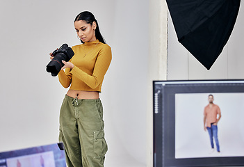 Image showing Serious, photographer and woman with camera in studio for shoot, magazine project or online content. Backstage, focus or girl videographer thinking for digital web fashion design or creative career