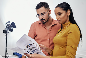 Image showing Documents, teamwork or planning with a photographer and model talking in a studio for creative production. Collaboration, designer or fashion with a designer man and woman at work on a magazine shoot